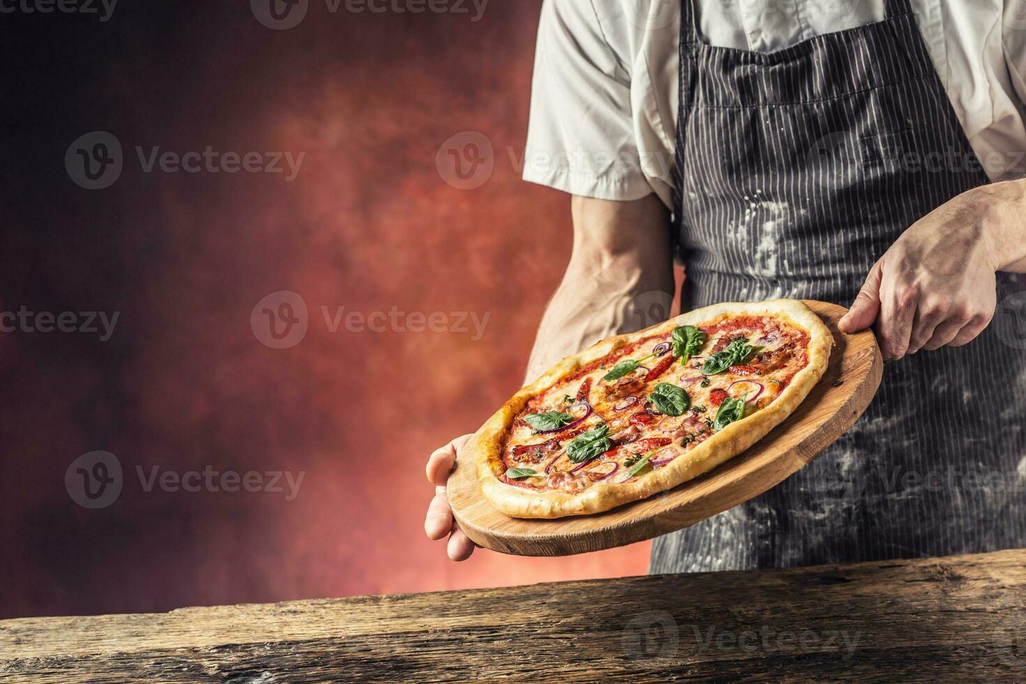 cocinero y Pizza. cocinero ofrecimiento Pizza en hotel o restaurante foto