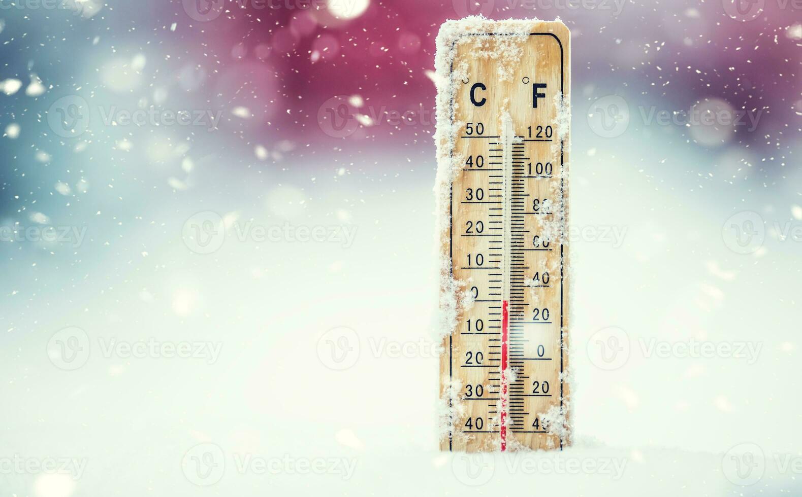 Thermometer on snow shows low temperatures in celsius or farenheit photo