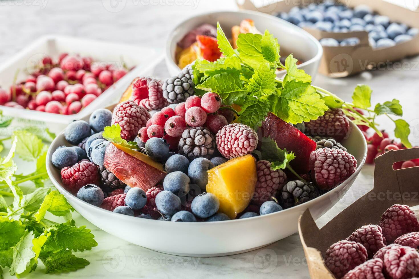 Frozen fruits blueberries blackberry raspberry red currant peach and herbs melissa photo