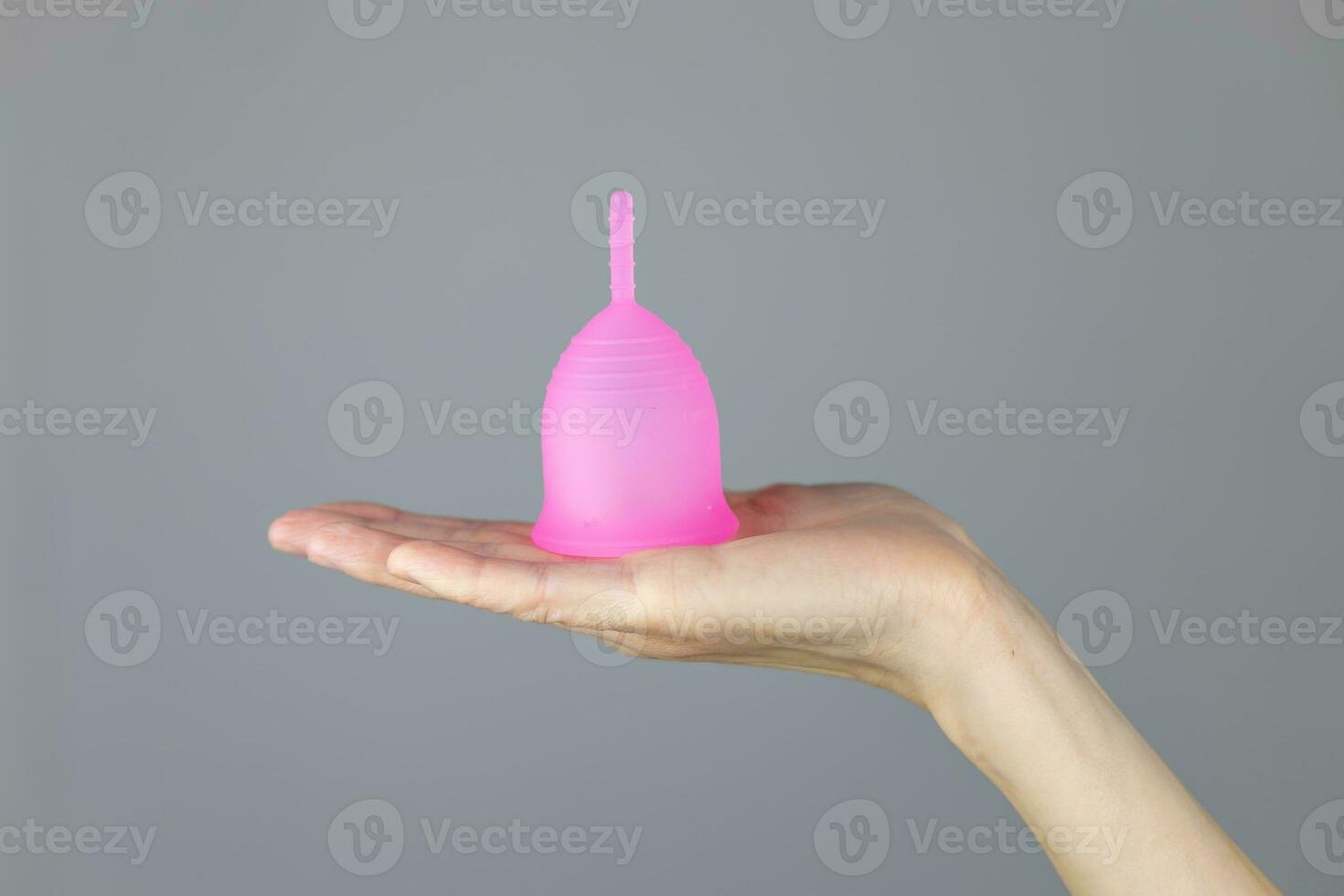 Close-up of a woman's hands holding a silicone menstrual cup. Alternative ecological feminine hygiene product during menstruation waste-free concept photo