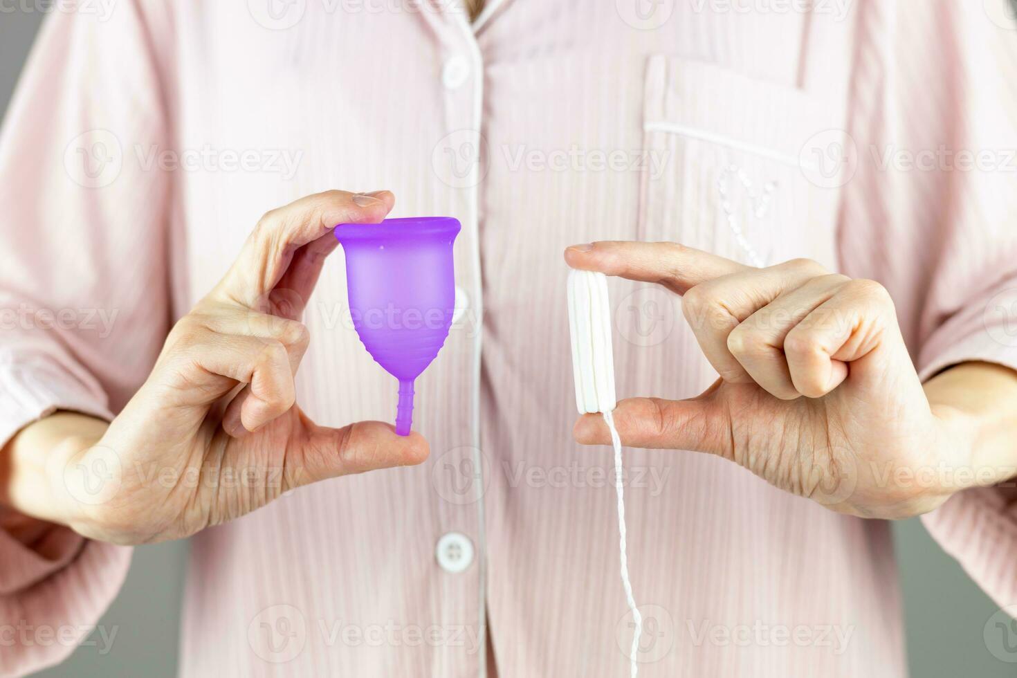 Close-up of a woman holding a choice of tampon or silicone menstrual cup in her hands. Alternative ecological feminine hygiene product during menstruation waste-free concept photo