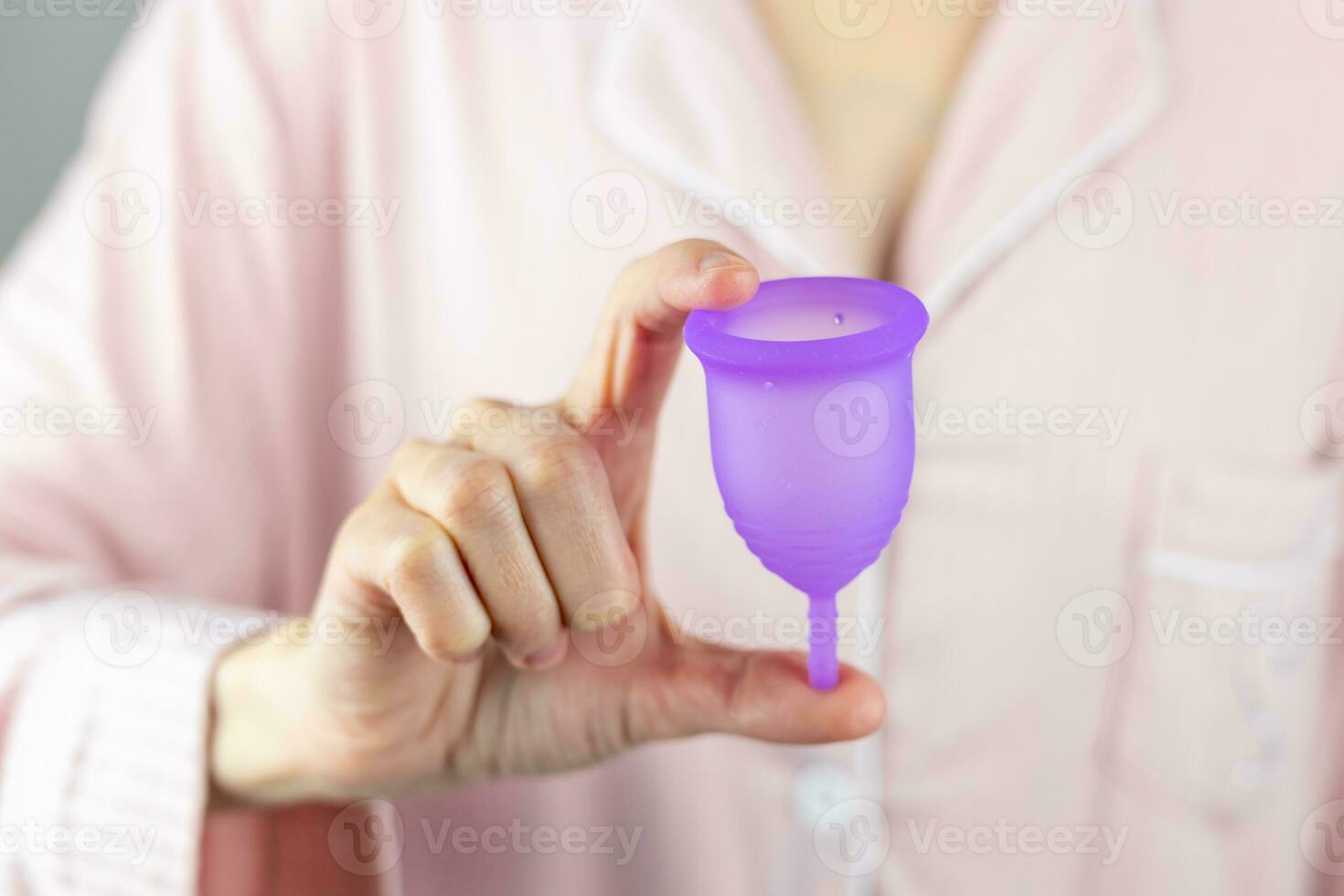 Close-up of a woman's hands holding a silicone menstrual cup. Alternative ecological feminine hygiene product during menstruation waste-free concept photo