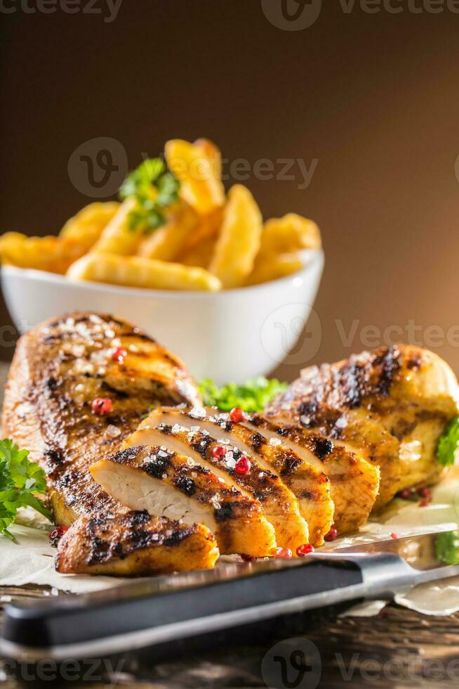 Grill chicken breast salt pepper parsley herbs and french potato fries photo