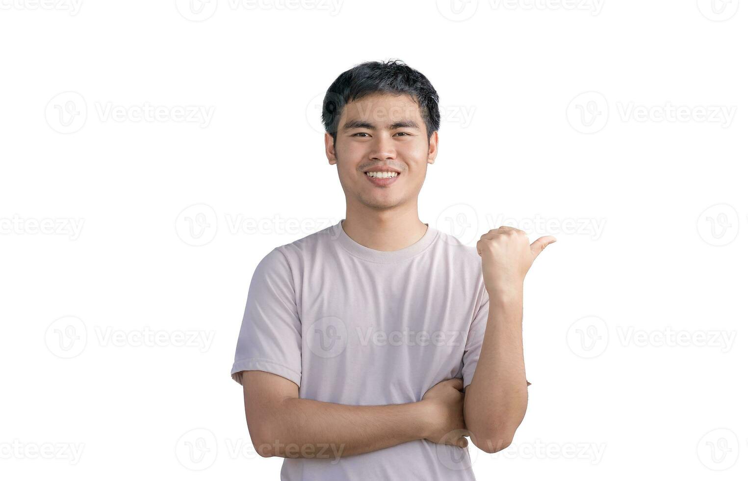 A young Asian man with crossed arms in a casual t-shirt and bristle on his face smiling on camera with thumb up over white background. photo