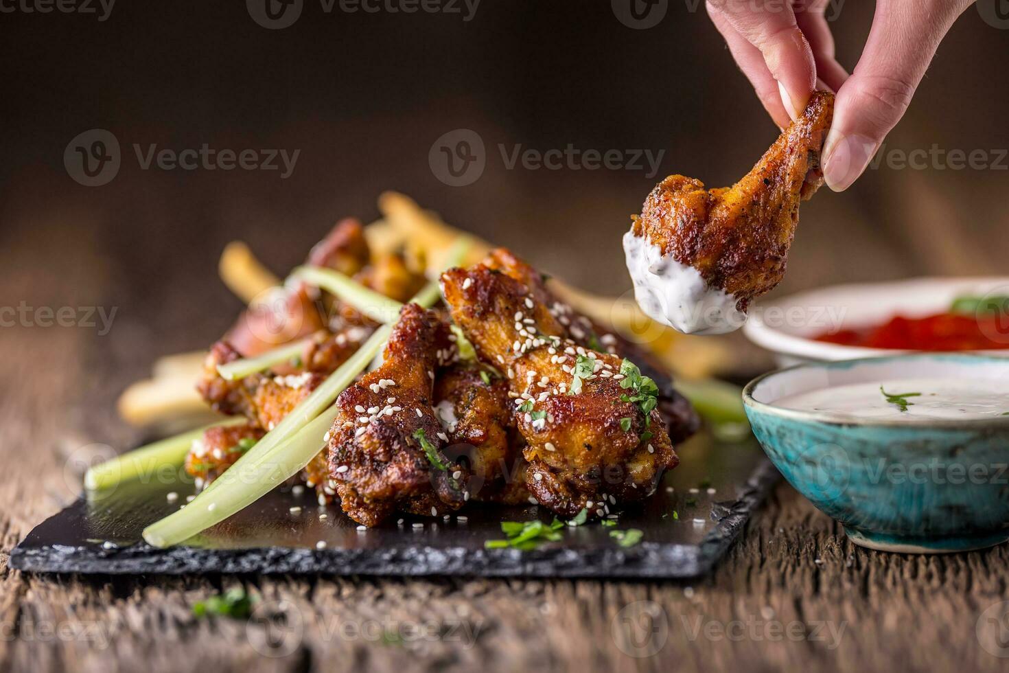 Chicken wings. Fried chicken wings in white bowl garlic dressing ketchup and potato fries. photo