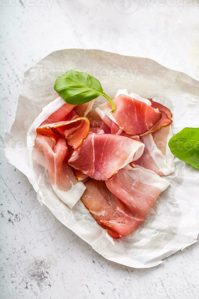 Prosciutto Olives olive oil mozzarella cheese tomatoes basil -  ingredients italian or mediterranean cuisine. photo