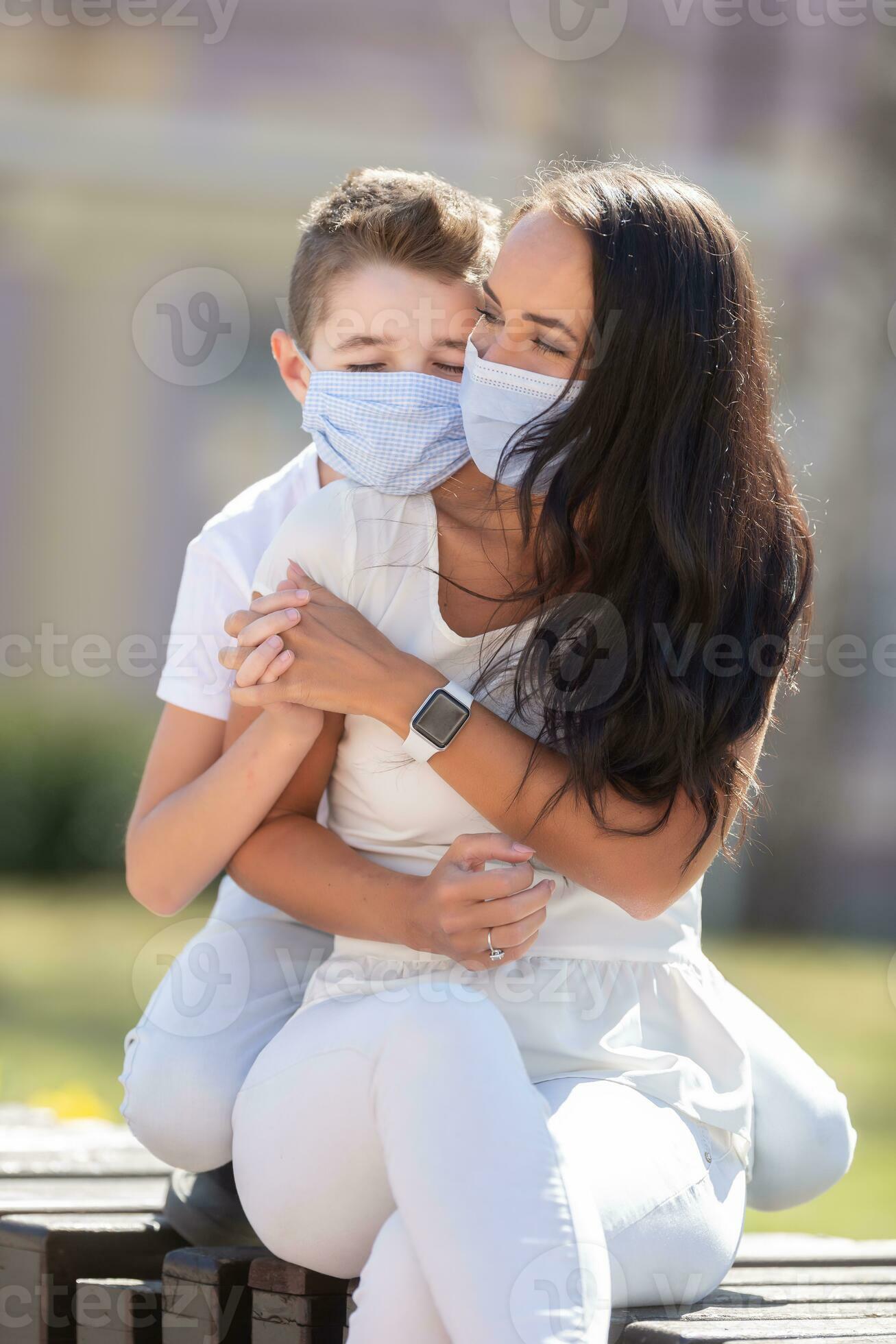 Littley boy helping his mother to put on a face mask stock photo