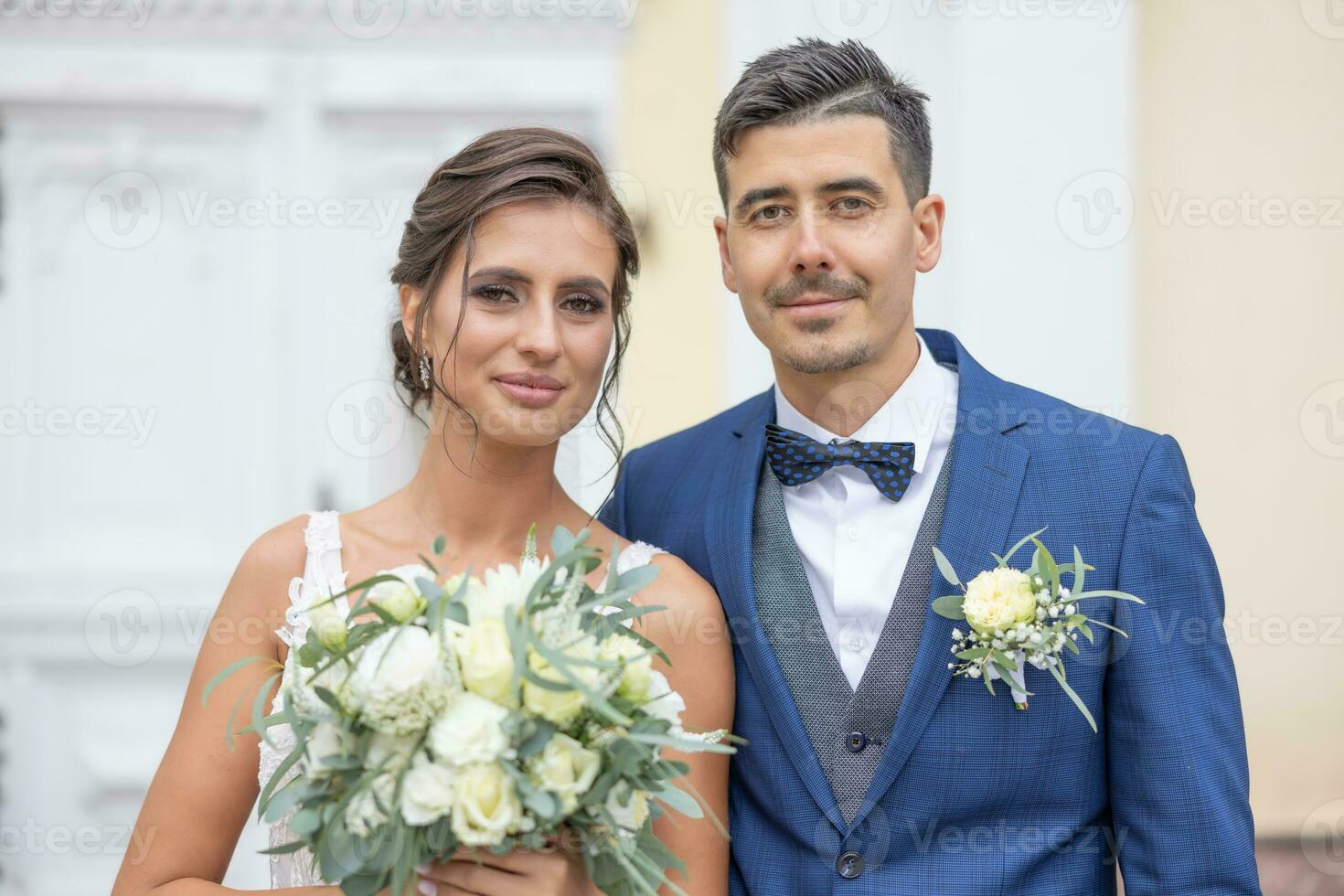 Beautiful young newlyweds smiling to the camera shortly after getting married photo