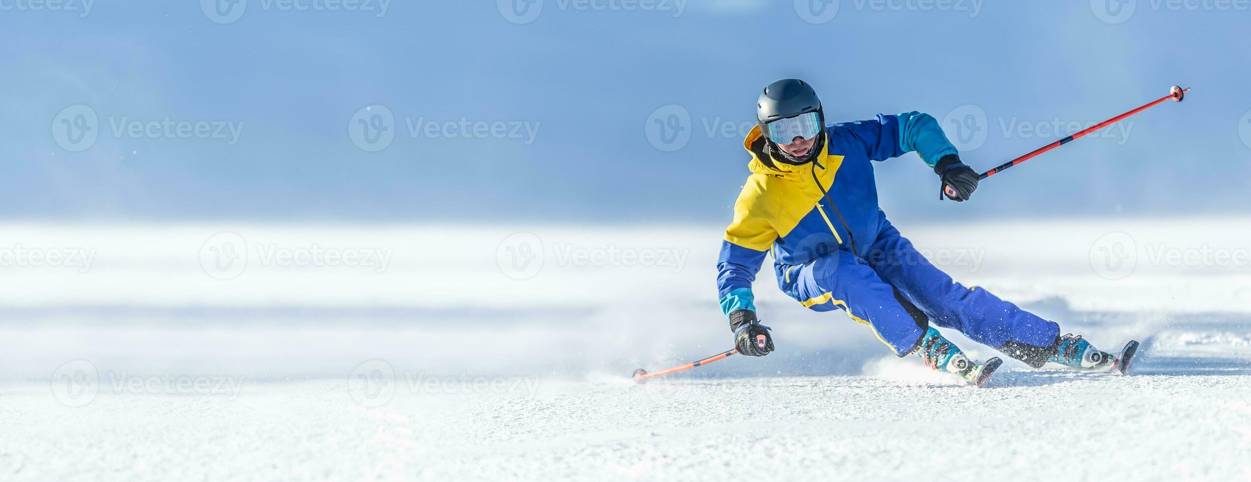 A young aggressive skier on an alpine slope demonstrates an extreme carving skiing style. photo