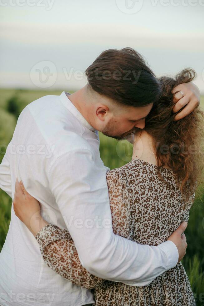 Couple in love on green field of wheat photo