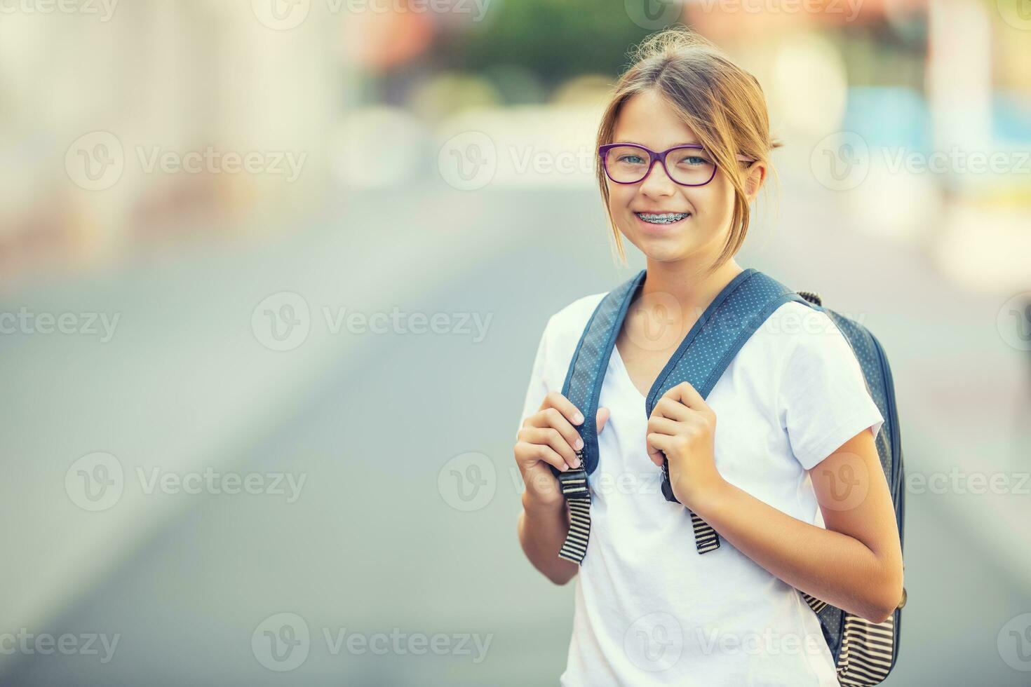 Chica de escuela con bolsa, mochila. retrato de moderno contento adolescente colegio niña con bolso mochila. niña con dental tirantes y lentes foto