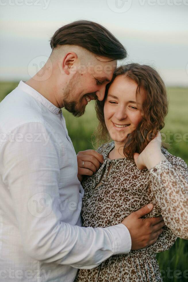 Couple in love on green field of wheat photo