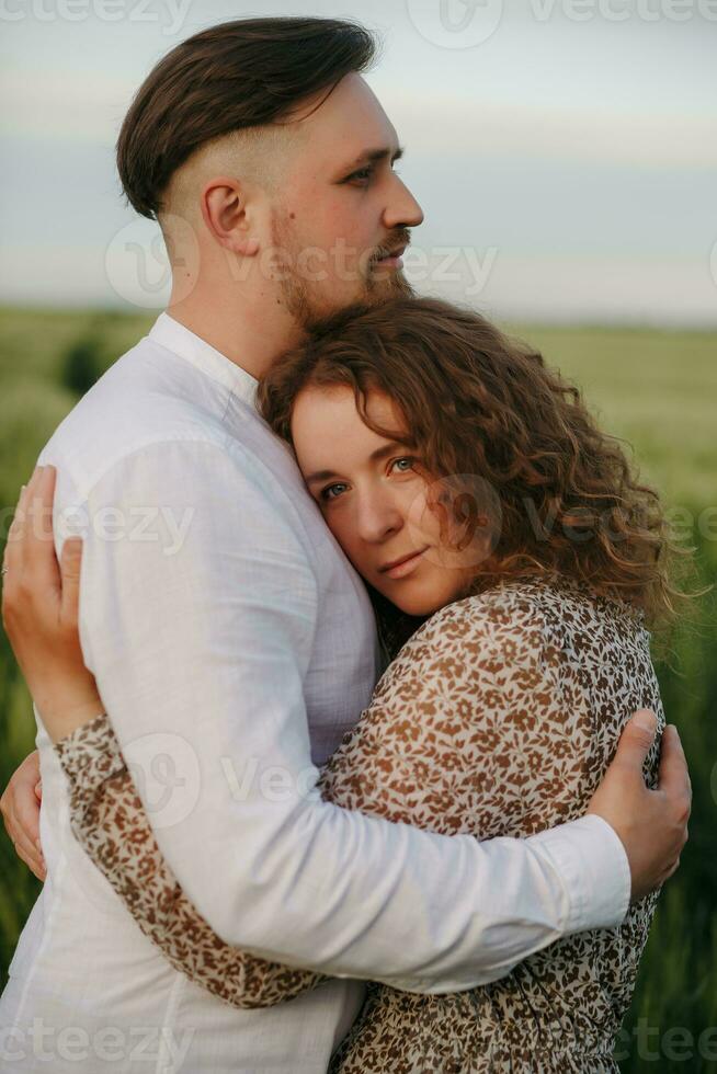 Couple in love on green field of wheat photo