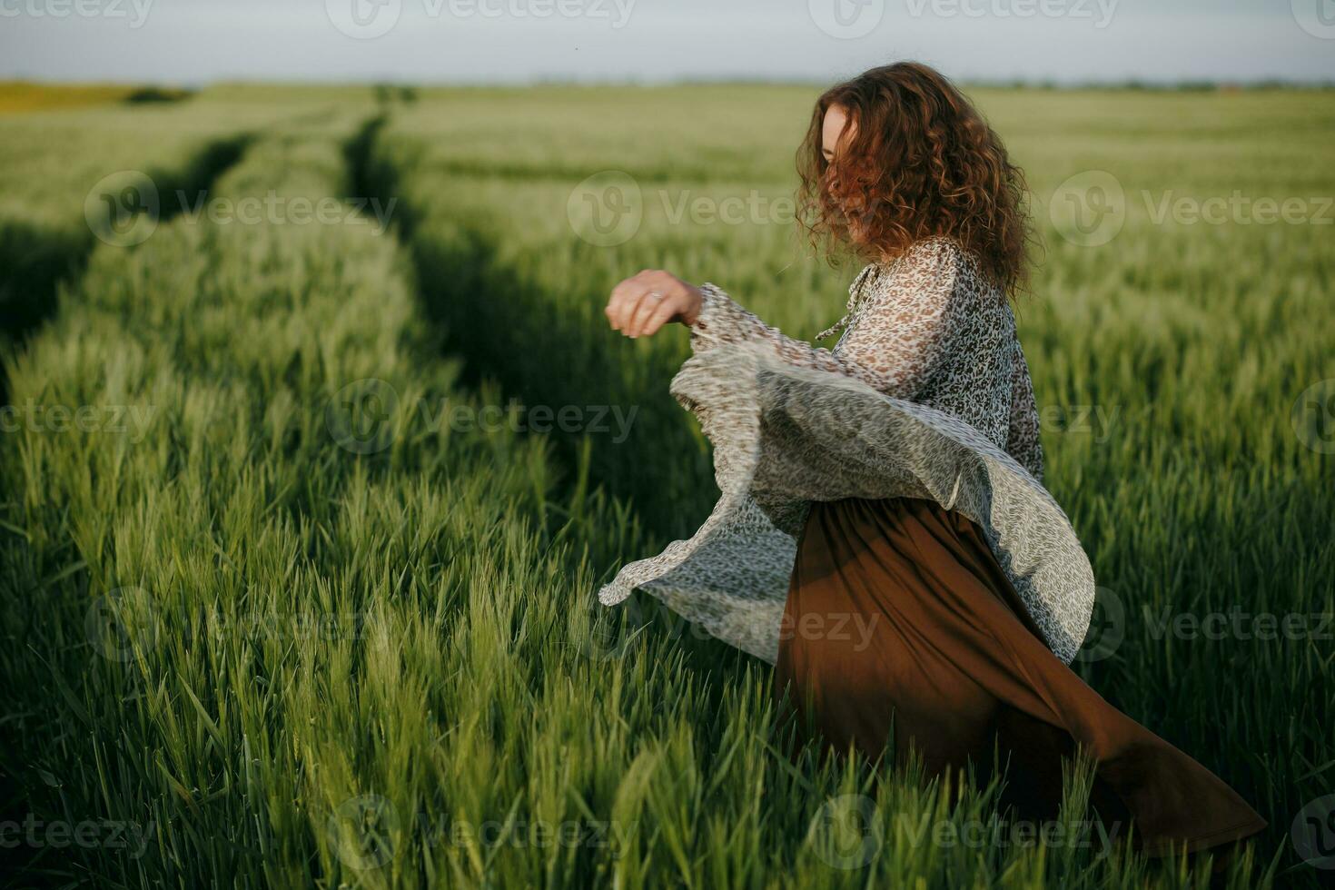 Curly girl dancing on the field photo