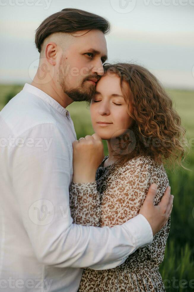 Couple in love on green field of wheat photo