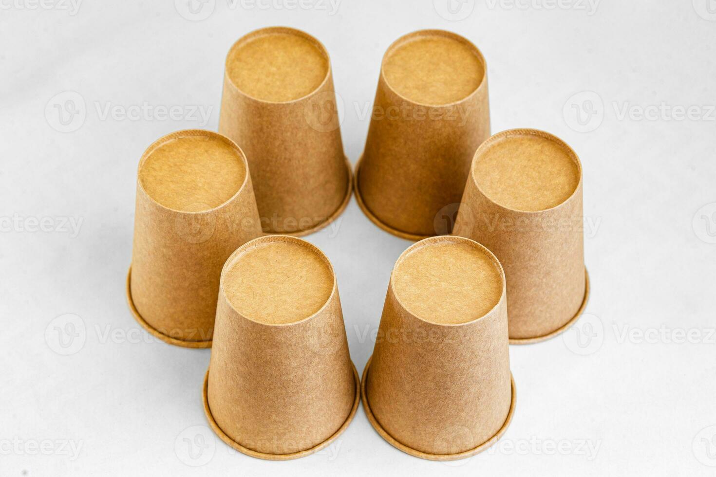 Stack of paper mugs. Six disposable paper cups made of cardboard kraft paper. photo