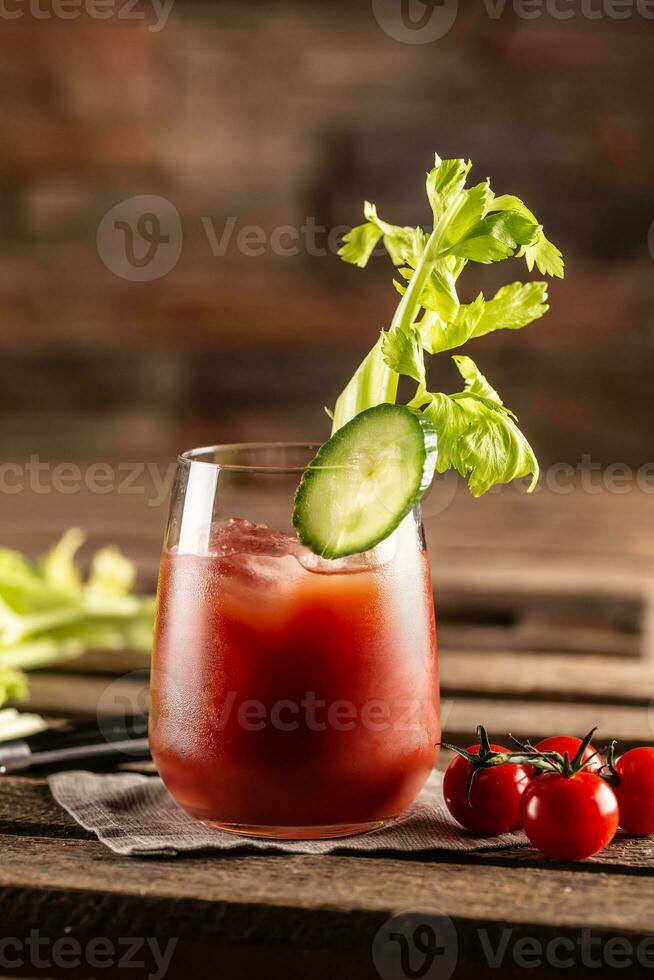 Classic bloody mary or virgin mary vodka cocktail in a cup with as a hangover drink in a rustic envrionment photo