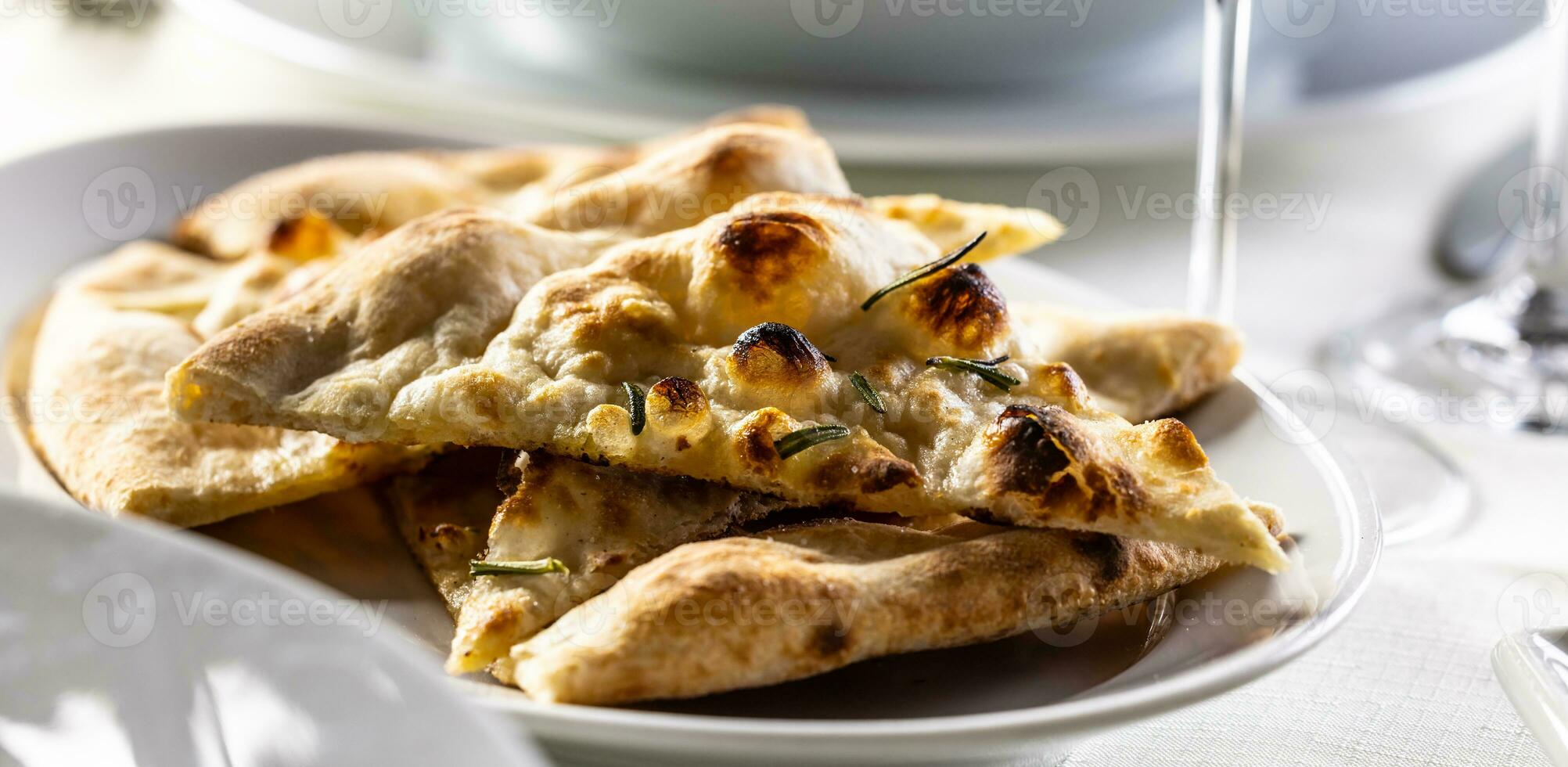 Fresh warm naan bread sliced and served on a plate photo