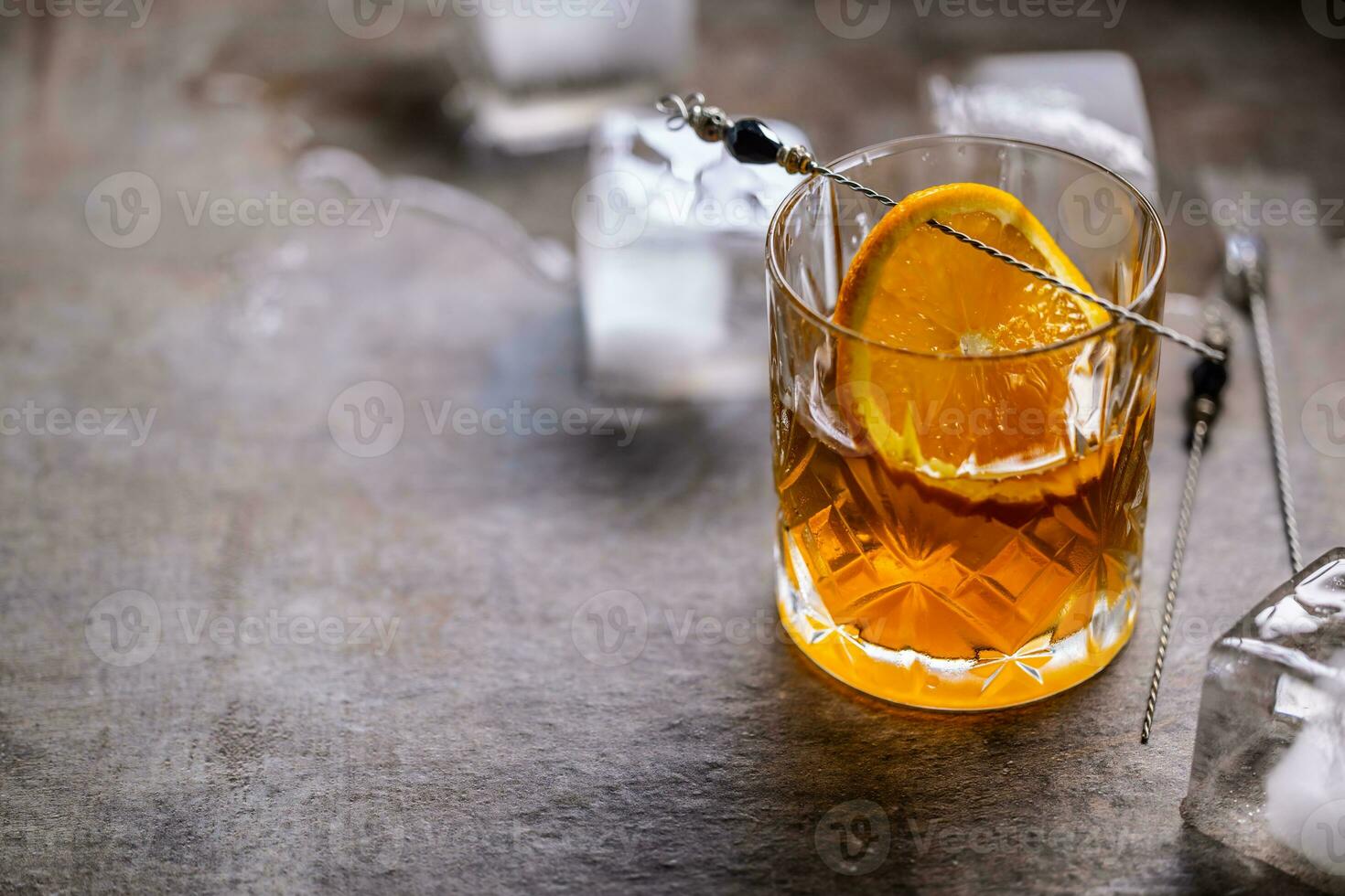 Glass of whiskey with ice cubes on the stoneware table with copy space - Old fashioned cocktail drink photo