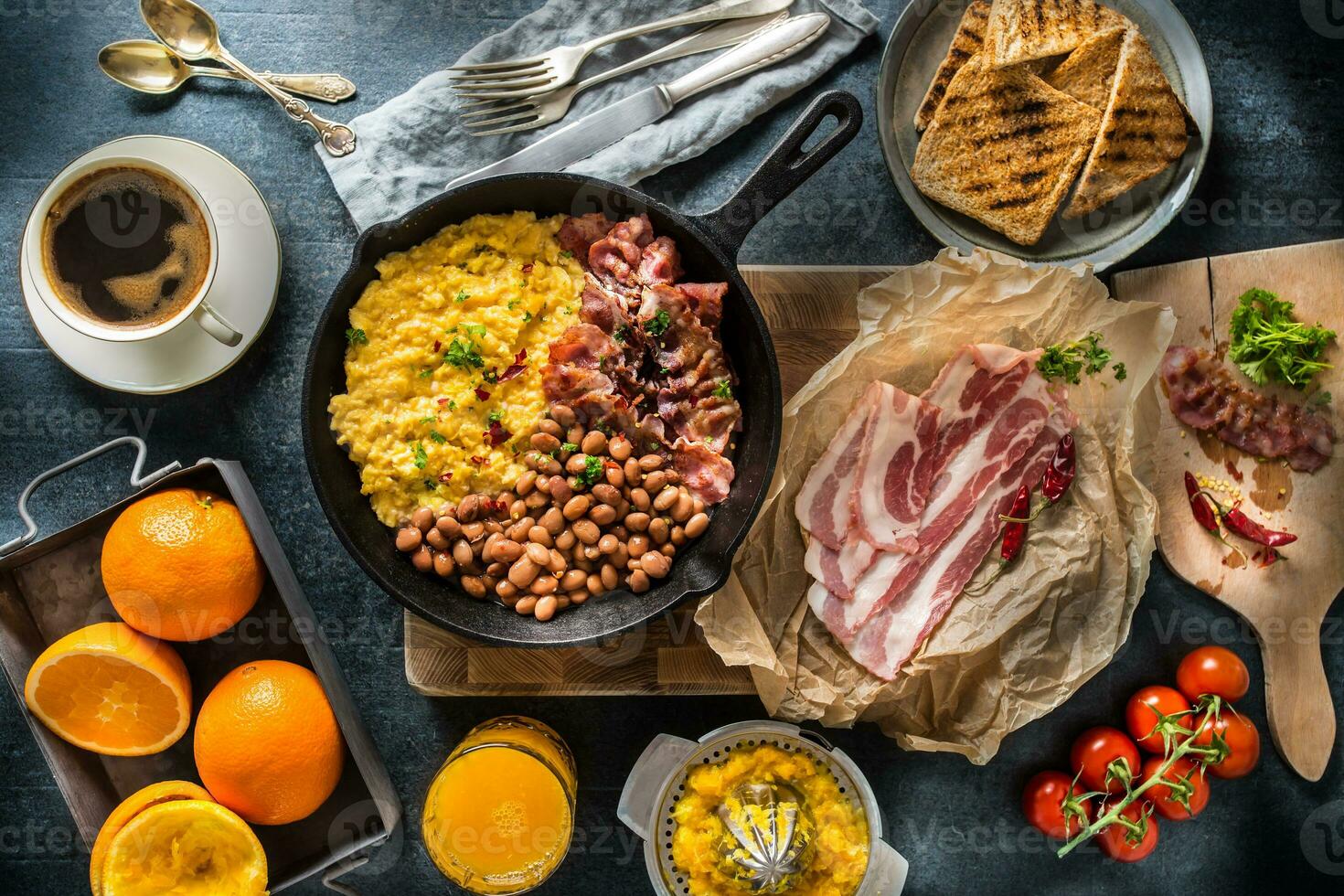 Full table of english breakfast. Scrambled eggs grilled bacon beans toast bread orange juice and coffee photo