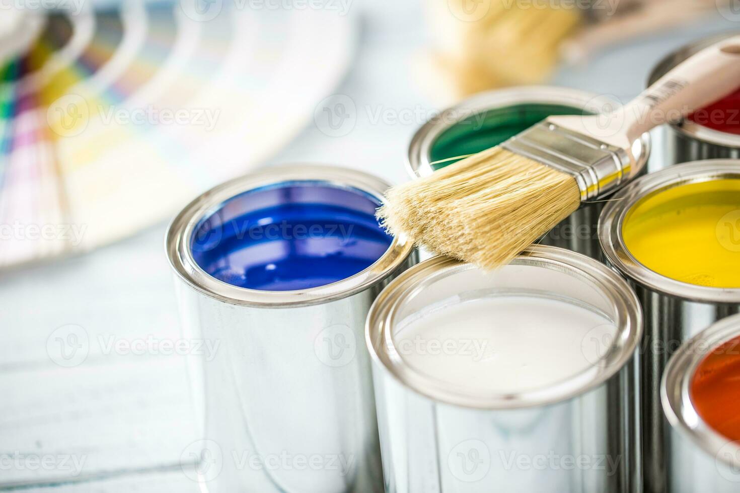 pintar latas cepillos y color paleta en mesa foto