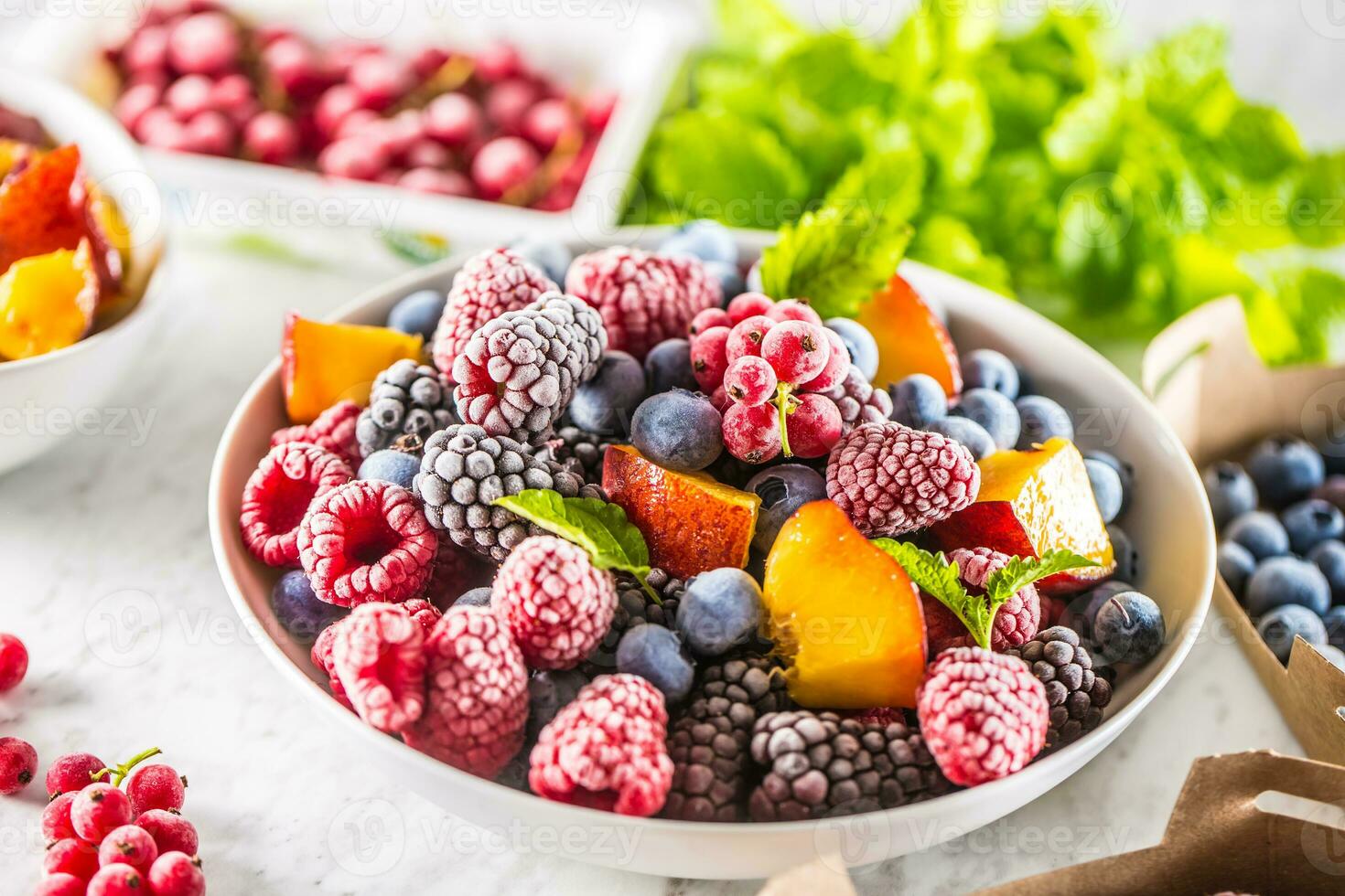 Frozen fruits blueberries blackberry raspberry red currant peach and herbs melissa photo