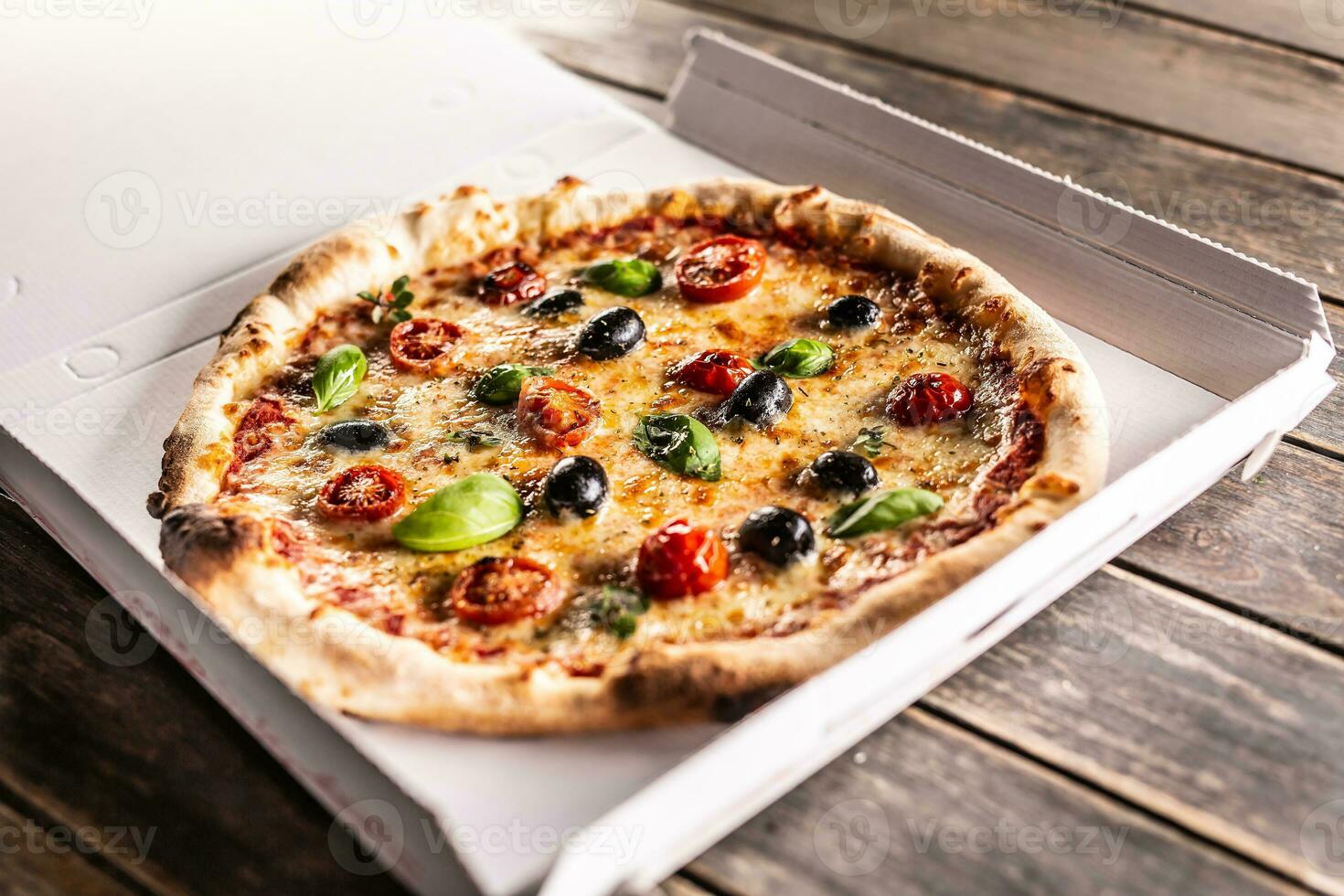 Pizza in a cardboard box on table ready to customer. photo