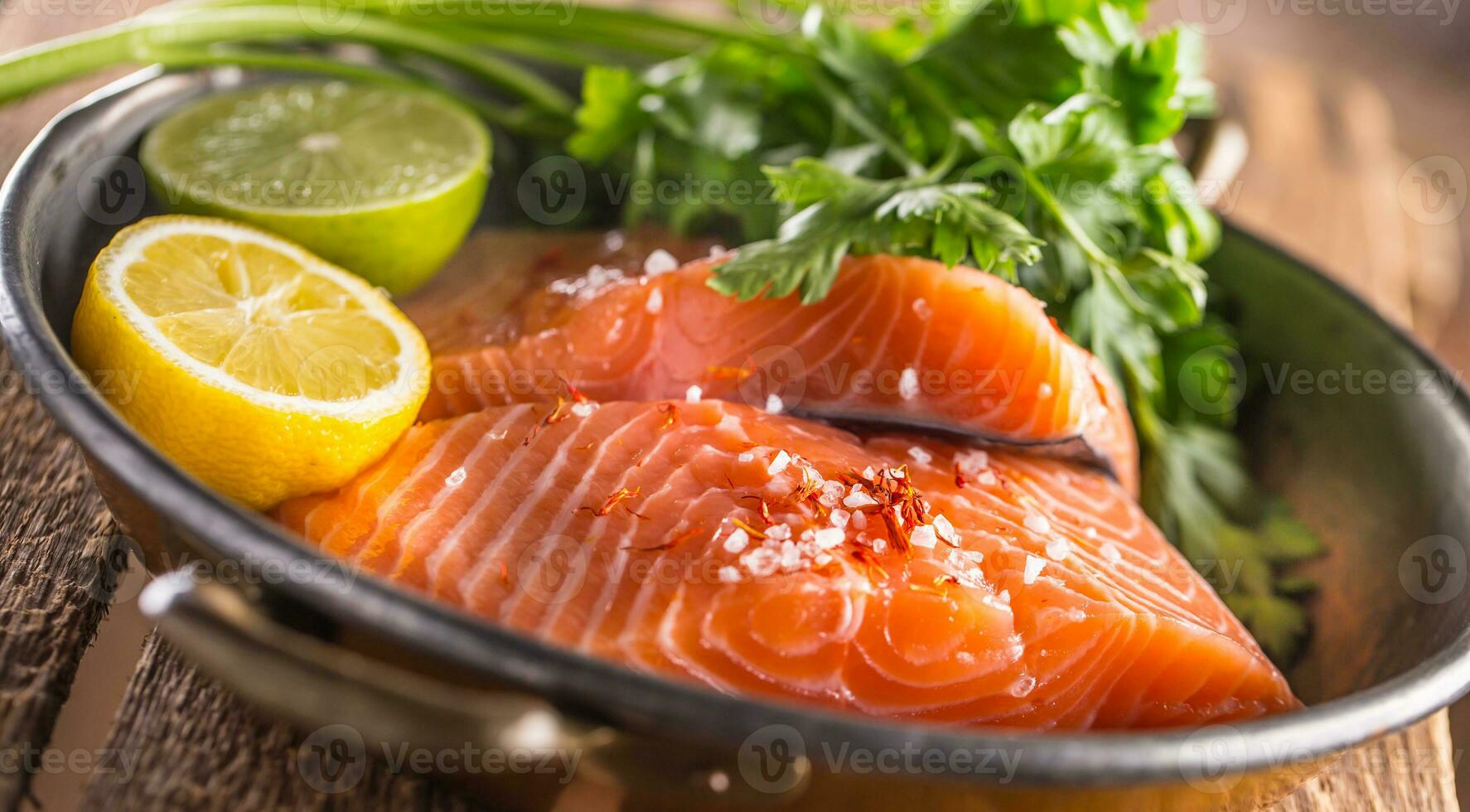 Raw salmon fillets with parsley herbs lime lemon salt and dried saffron photo