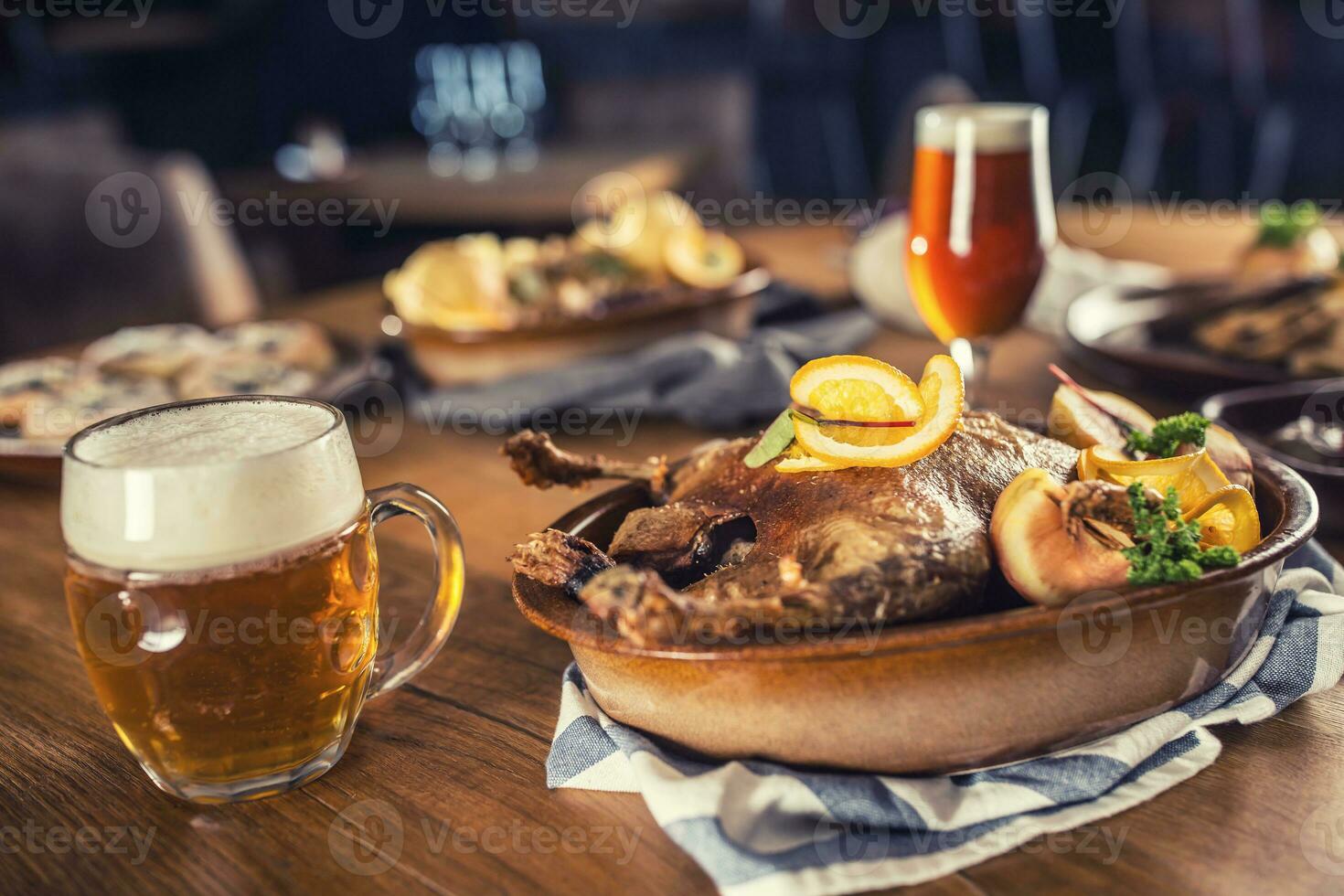 Roasted christmas duck red cabbage dumplings liver draft beer and baked buns. photo