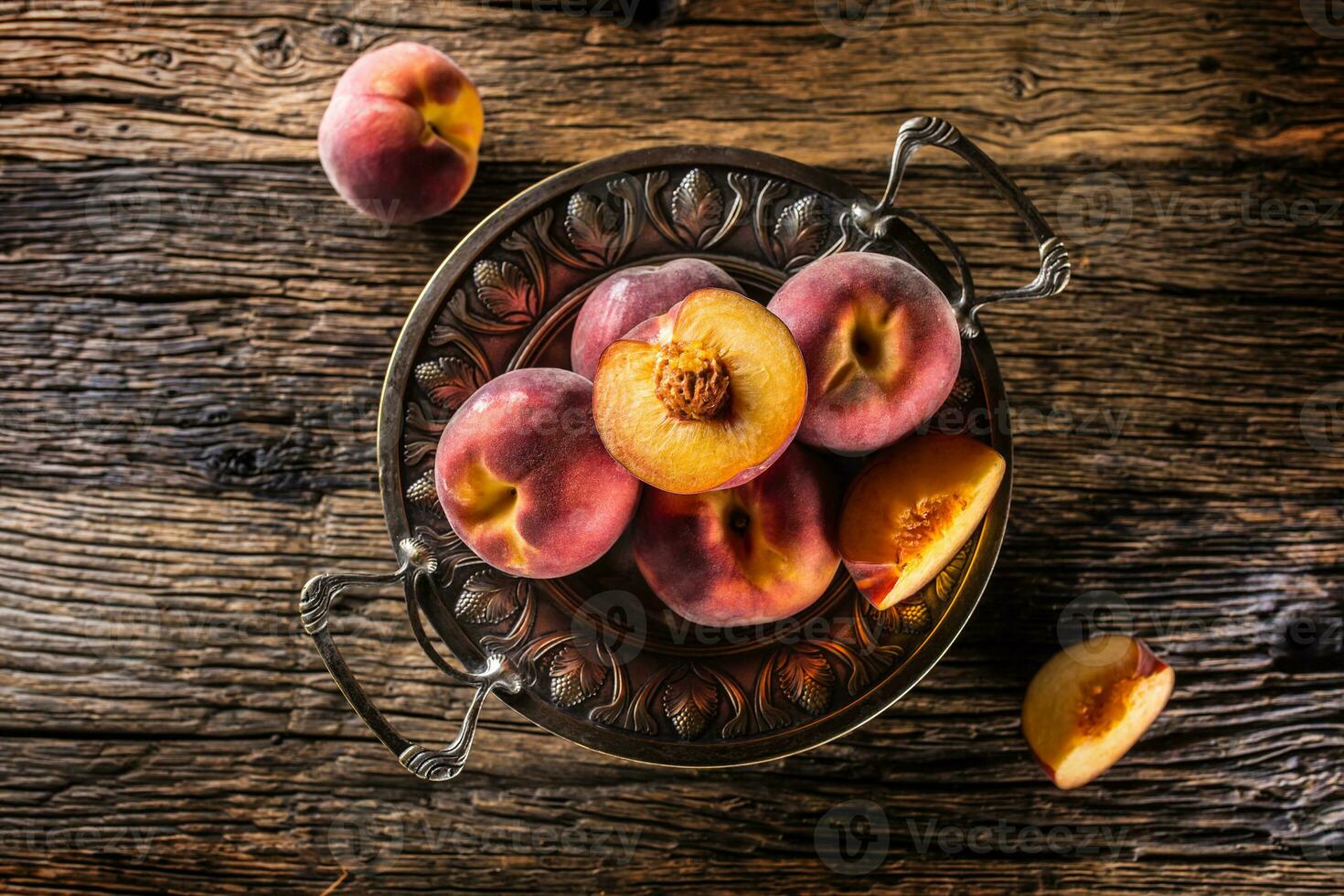 Ripe peaches in rustic bowl and wooden table photo