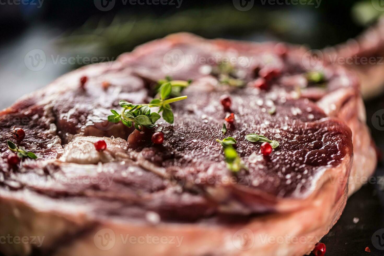 crudo carne de vaca tomahawk filete con sal pimienta y Romero en pizarra plato foto