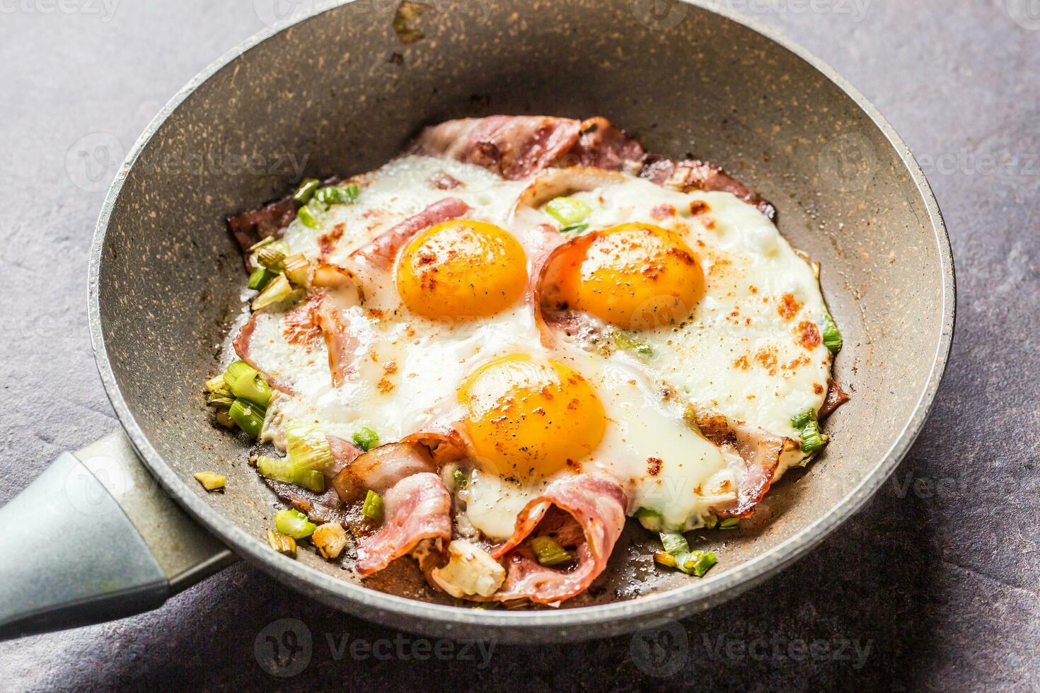 English breakfast fried bacon ham and eggs in ceramic pan photo