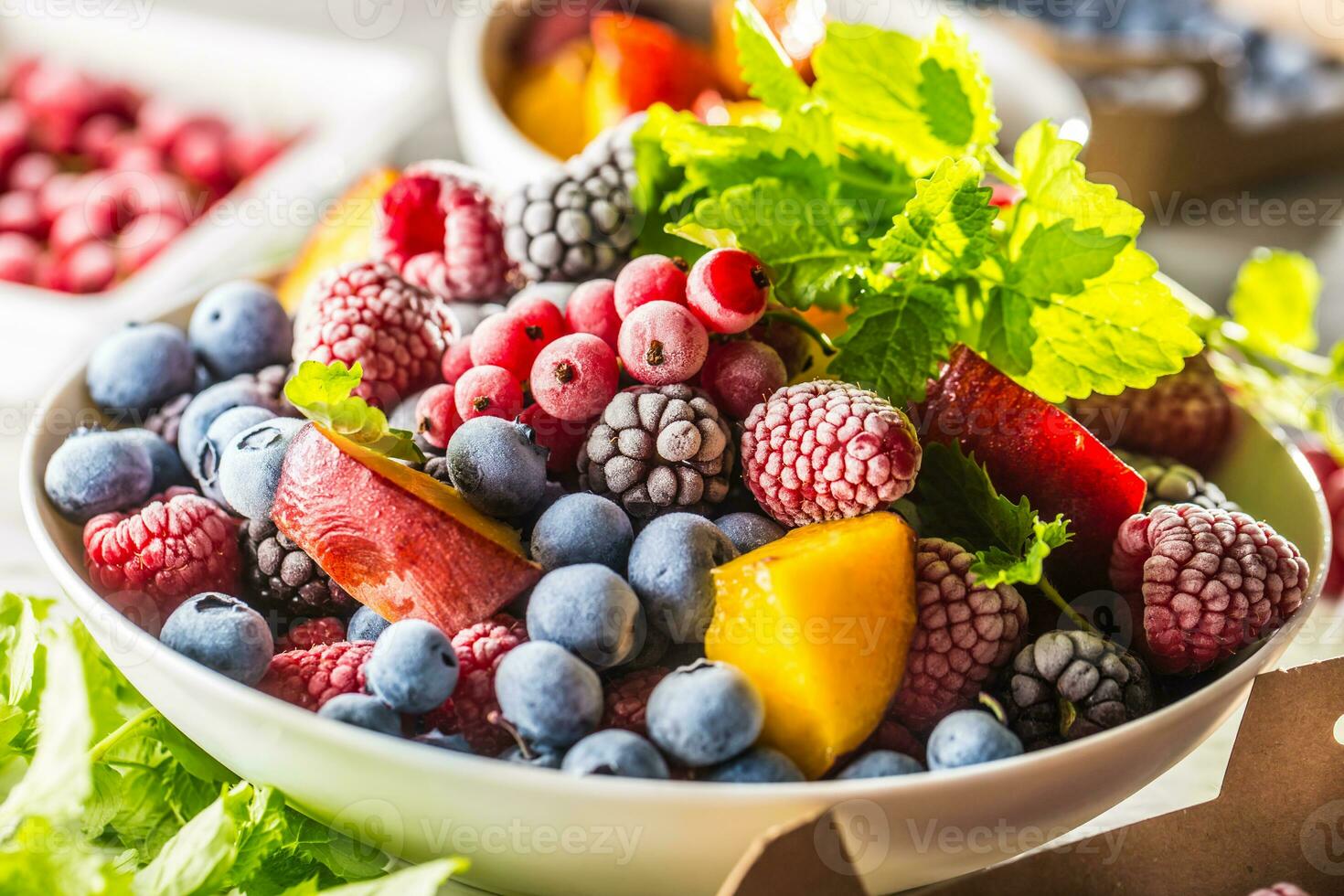 Frozen fruits blueberries blackberry raspberry red currant peach and herbs melissa photo