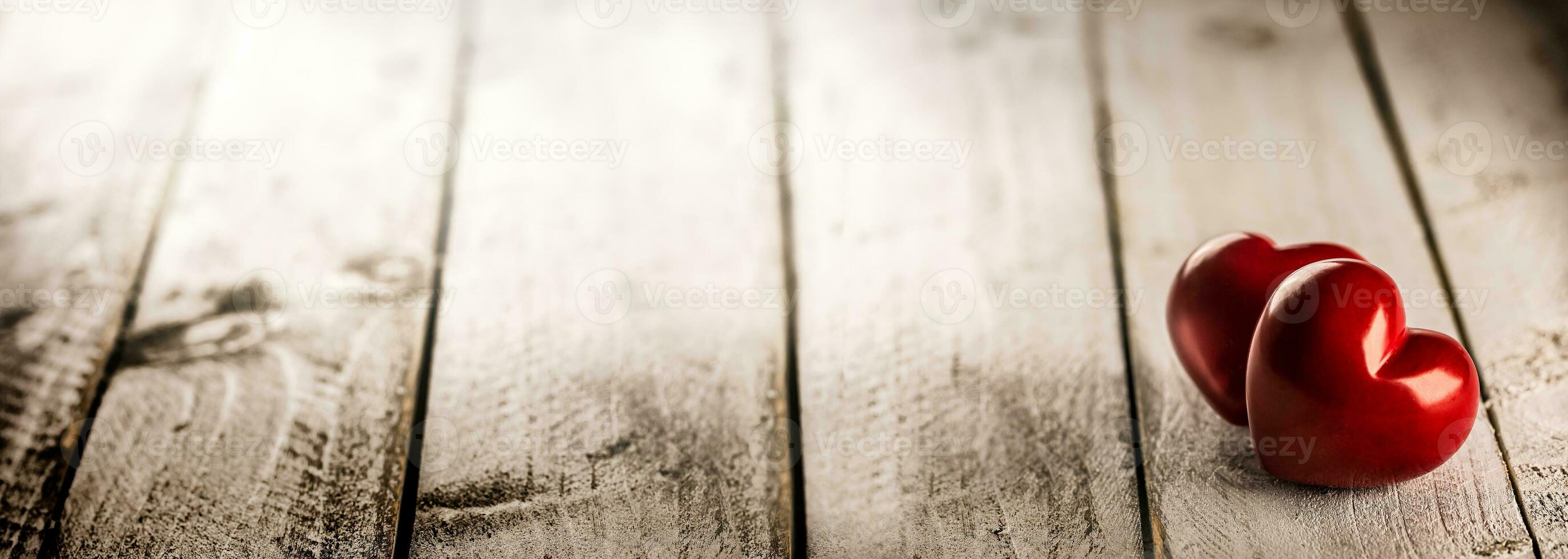 Two red valentines hearts on wooden table. photo