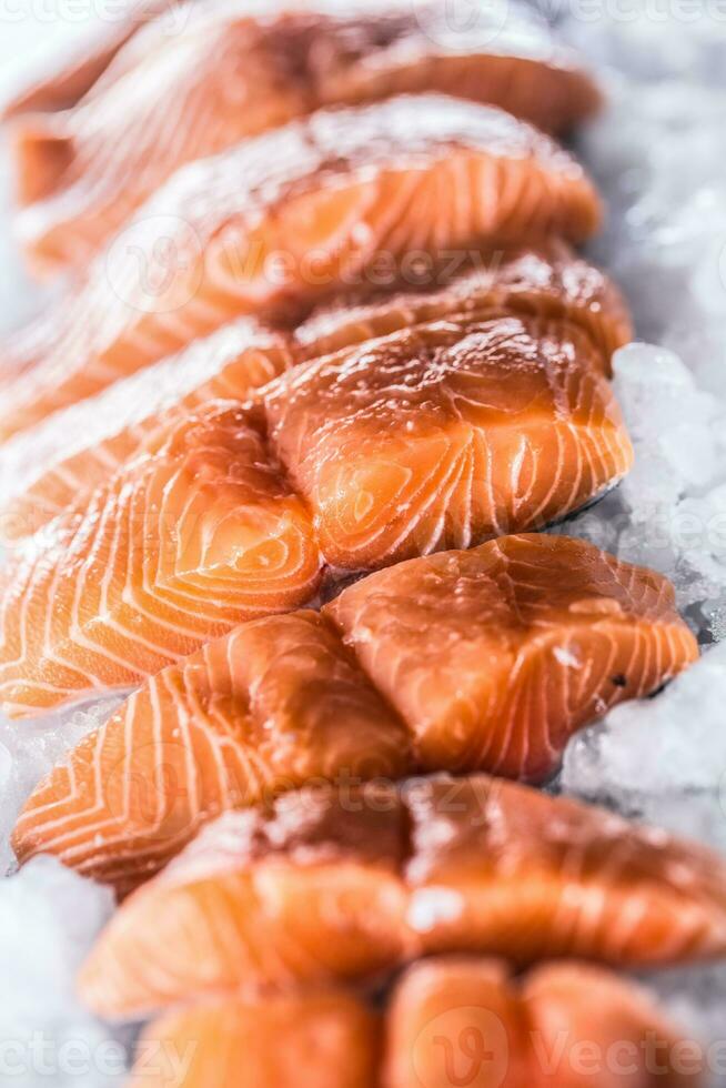 salmón filetes en porciones en hielo y vacío cocina tablero foto