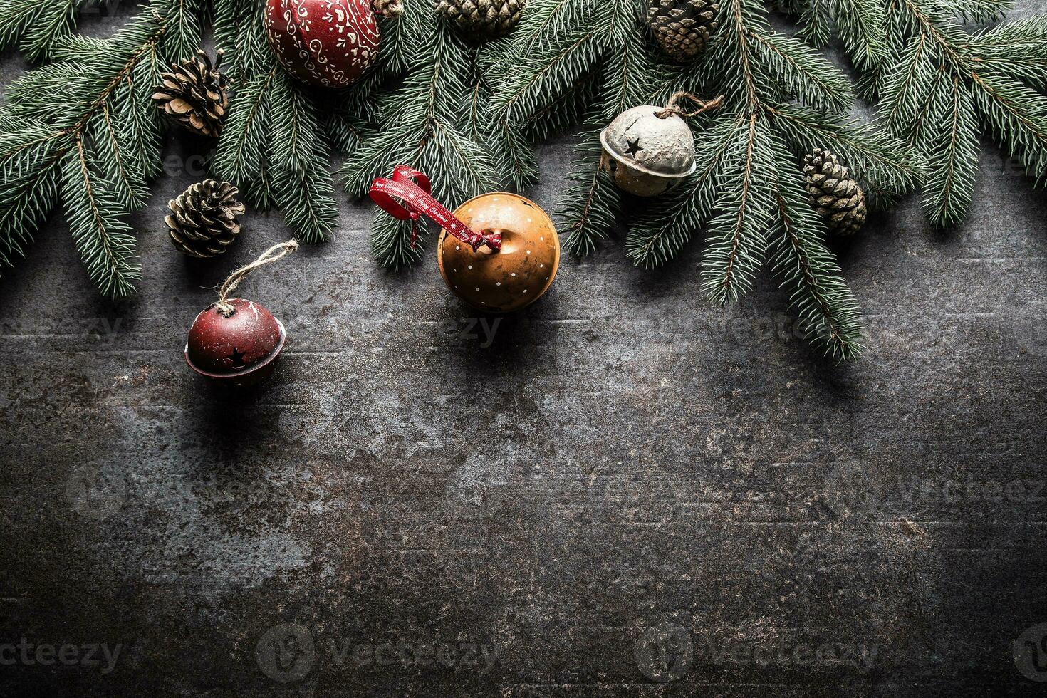 Top of view christmas decorations jingle bells fir tree pine cones on free concrete background photo