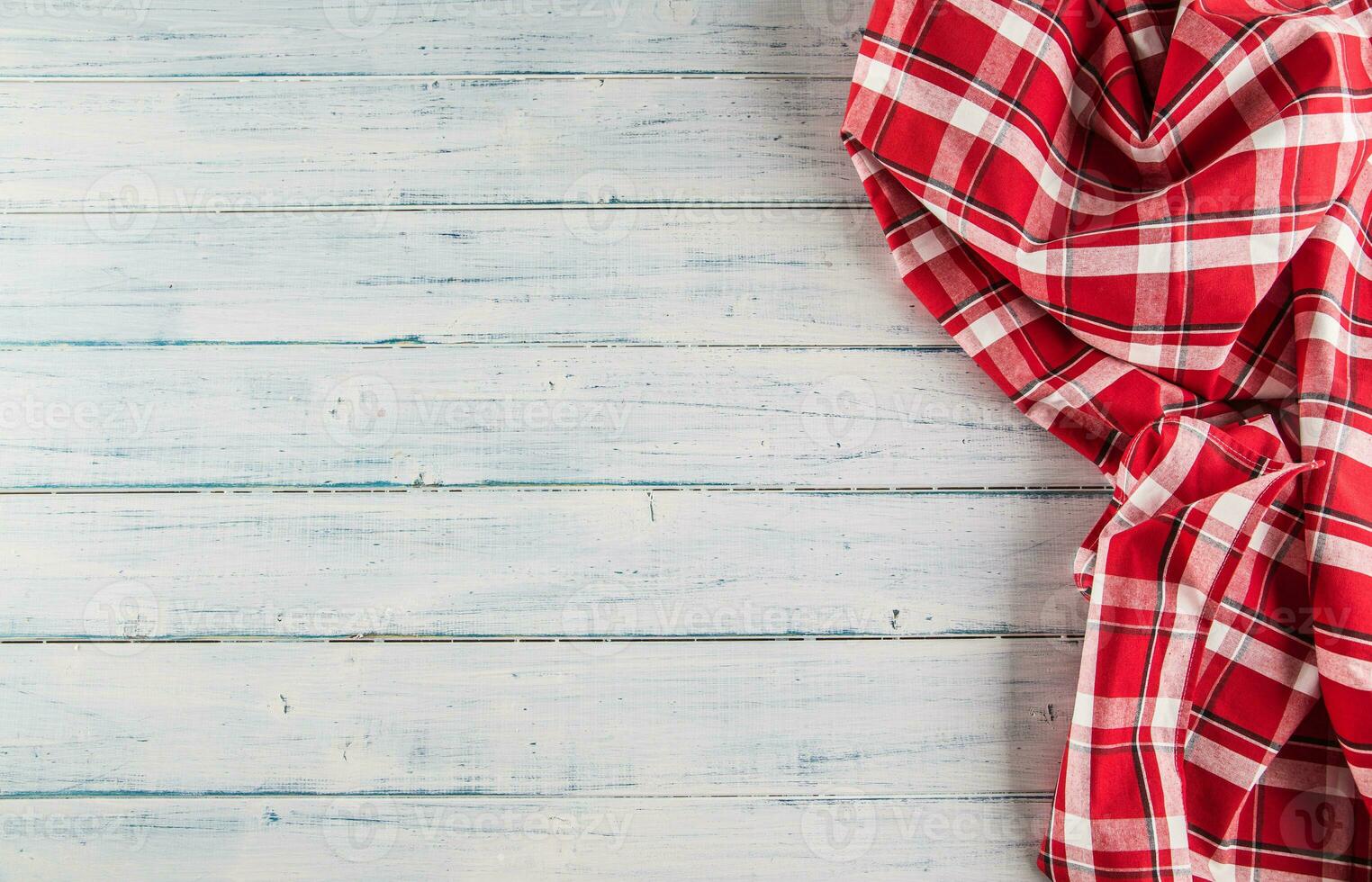 Top of view red checkered tablecloth on wooden table photo