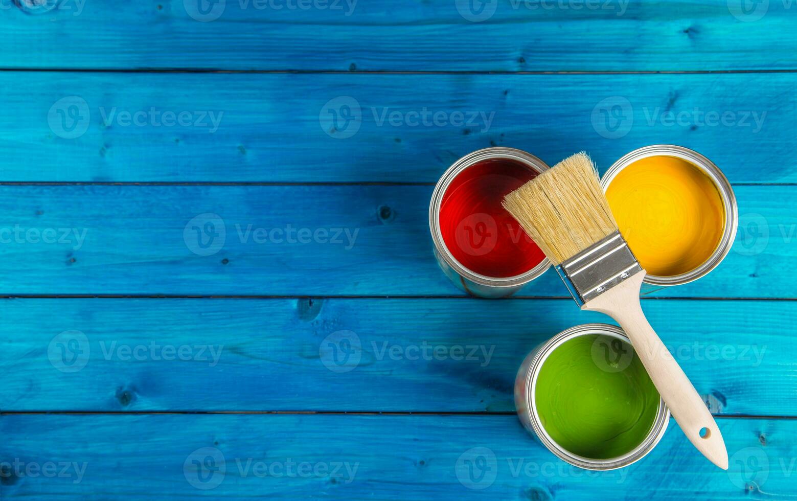 Paint cans color palette, cans opened with brushes on blue table
