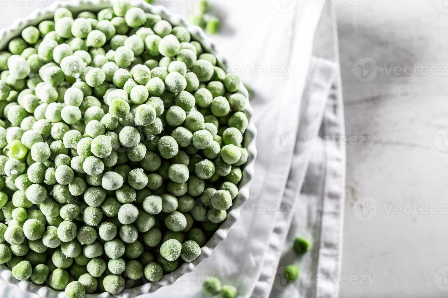 Frozen peas in a white porcelain bowl. photo