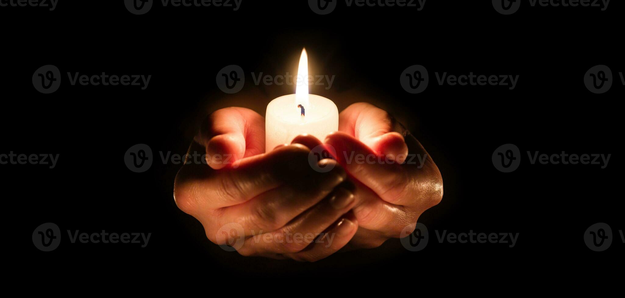 Burning candle in woman hands over black. Religious christmas spa and wellness concept photo