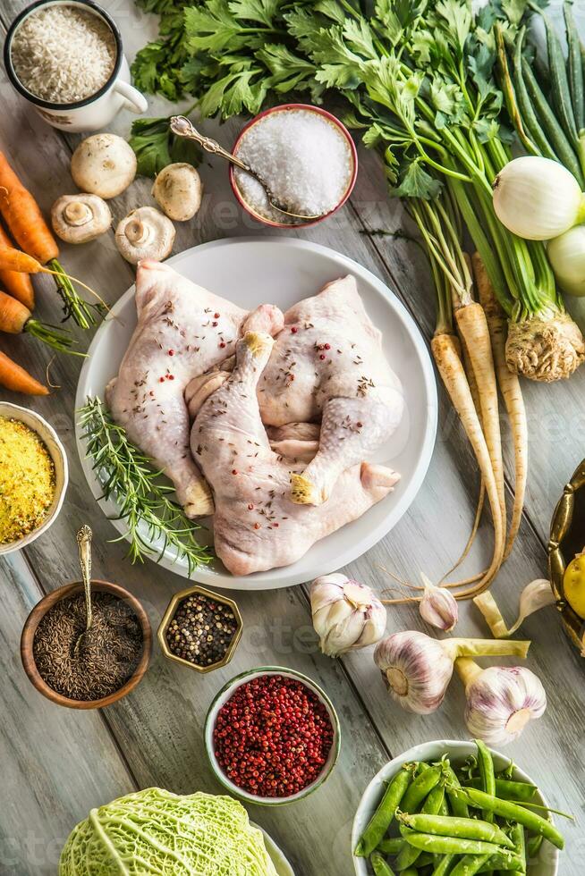 crudo pollo piernas con surtido especias y vegetales. foto