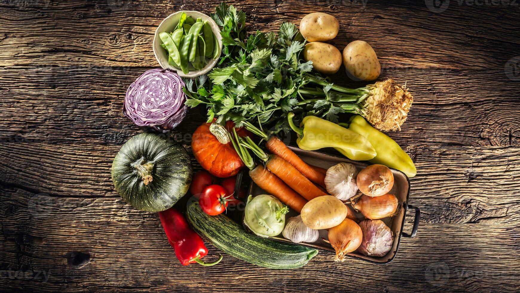 Assortment of fresh vegetables in a basket on a wooden table photo