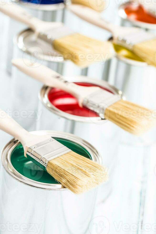 Close-up brushes lying on multicolored paint cans. photo