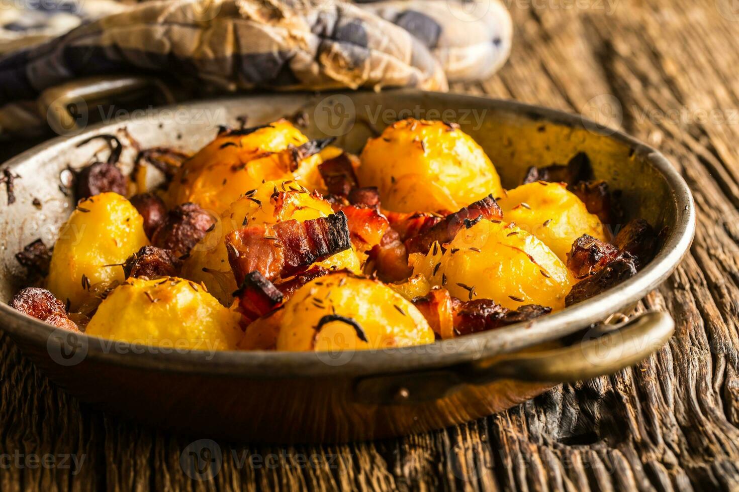 Potatoes. Roasted potatoes with bacon onion and sausages on old oak