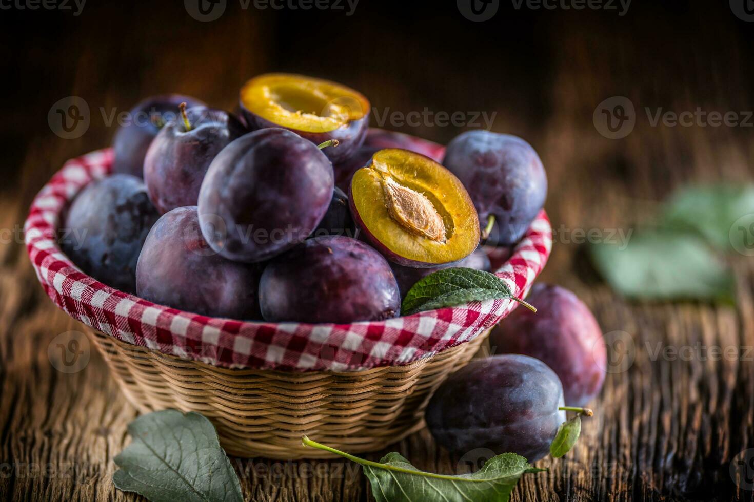 Plums. Fresh juicy plums in a bowl on a wooden or concrete board photo