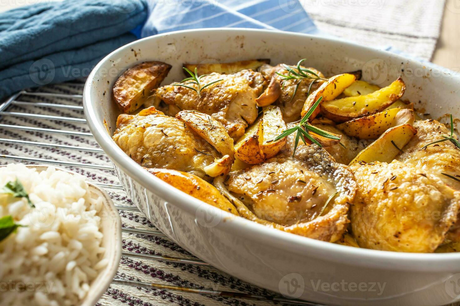 Chicken legs roasted with american potatoes in baking dish photo