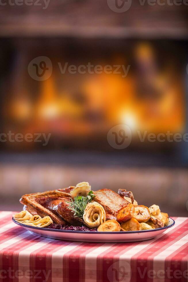Festive garnished roast duck with apples and red cabbage photo
