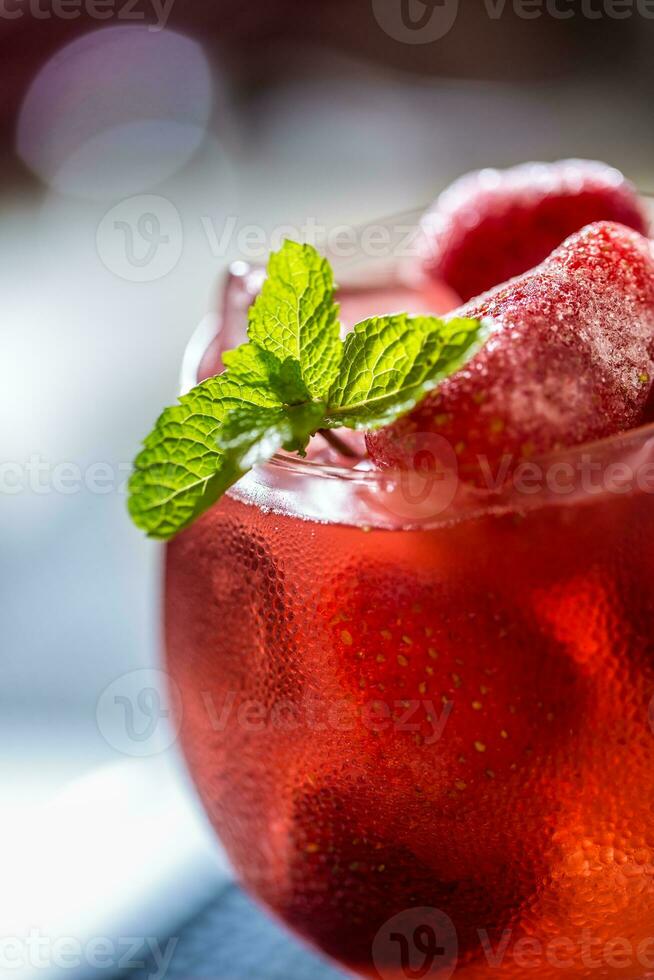 Strawberry lemonade or alcoholic cocktail with ice syrup soda and mint leaves. photo