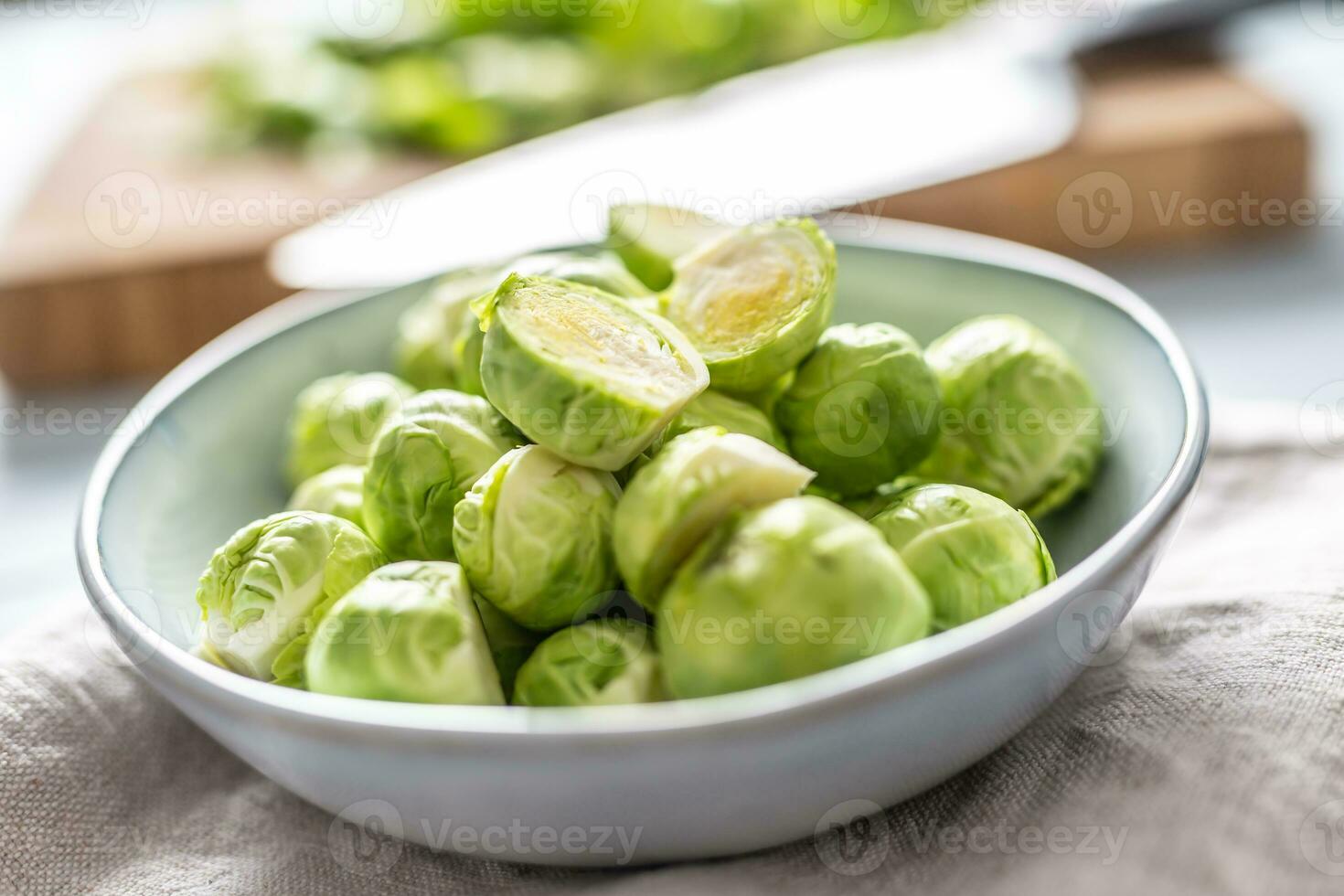 Fresh brusseles sprouts in bowl on kitchen table photo