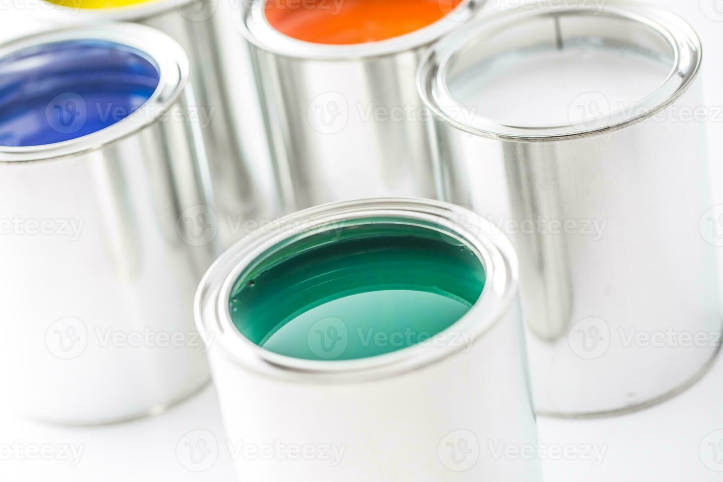 Full of multicolored paint cans on white table photo